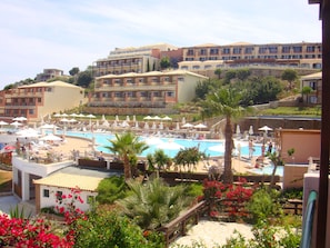 Relax by the pool surrounded by lush gardens and palm trees, with sun loungers and umbrellas at your disposal.