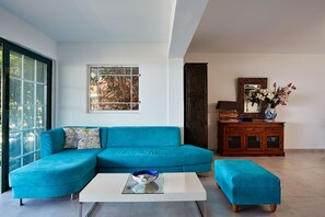 Relax in this stylish living room with a comfortable sofa, coffee table, and beautiful view of the surrounding greenery.