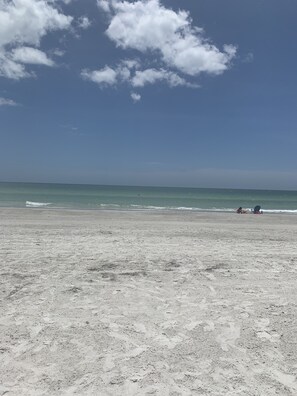 Na praia, espreguiçadeiras, toalhas de praia 