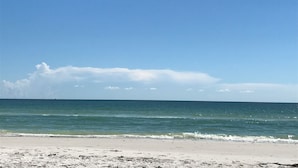 Ein Strand mit blauem Himmel und ruhiger See.