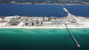 An aerial view of a coastal area with a long pier extending into the water, surrounded by high-rise buildings and a sandy beach. - Turtle's Nest-Gulf Front Home w/Gorgeous Furnishings. Sleeps 10 (Navarre)