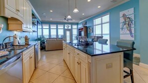 A spacious kitchen with a central island, white cabinetry, and a blue accent wall. - Turtle's Nest-Gulf Front Home w/Gorgeous Furnishings. Sleeps 10 (Navarre)