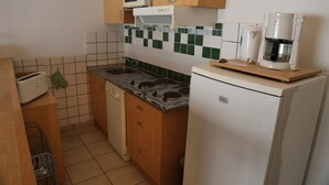A compact kitchen with a stove, microwave, and coffee maker. - T2 apartment Beachfront (Banyuls-Sur-Mer)
