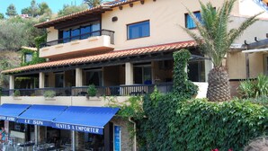 A two-story building with a balcony, outdoor seating, and a sign for 'Le Sun'. - T2 apartment Beachfront (Banyuls-Sur-Mer)