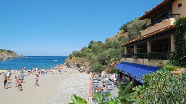 A beachside hotel with outdoor seating, a view of the sea, and a building with a tiled roof. - T2 apartment Beachfront (Banyuls-Sur-Mer)