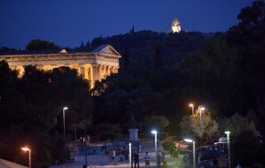 A historical building with classical architecture, surrounded by trees and illuminated by street lamps. - Thission Luxury Homes - Acropolis Residence by K&K (Athina)