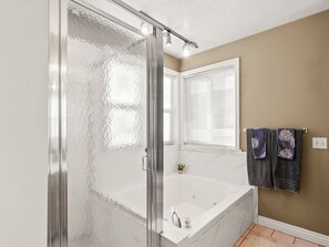 A bathroom with a glass shower door, a white bathtub, a small potted plant, and two towels hanging on a rack. - Alpine Basecamp: SKI, Hike, Bike, Hot Tub, Game Room, Pets Welcome, near lcc/bcc (Cottonwood Heights)