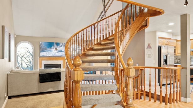 Un escalier en bois, dont les marches sont recouvertes de moquette, mène au deuxième étage.