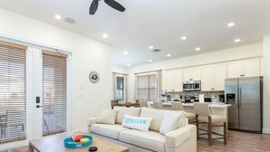 A modern kitchen with white cabinets, a stainless steel refrigerator, and a microwave. - Idyllic Waterfront Margaritaville Cottage w/ Private Pool & Spa (Kissimmee)
