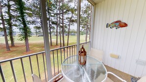 A covered outdoor area with a glass table and chairs, a lantern, and a decorative fish on the wall. - CH3509, Golf Course Escape, Your Ideal Vacation Home (Sunset Beach)