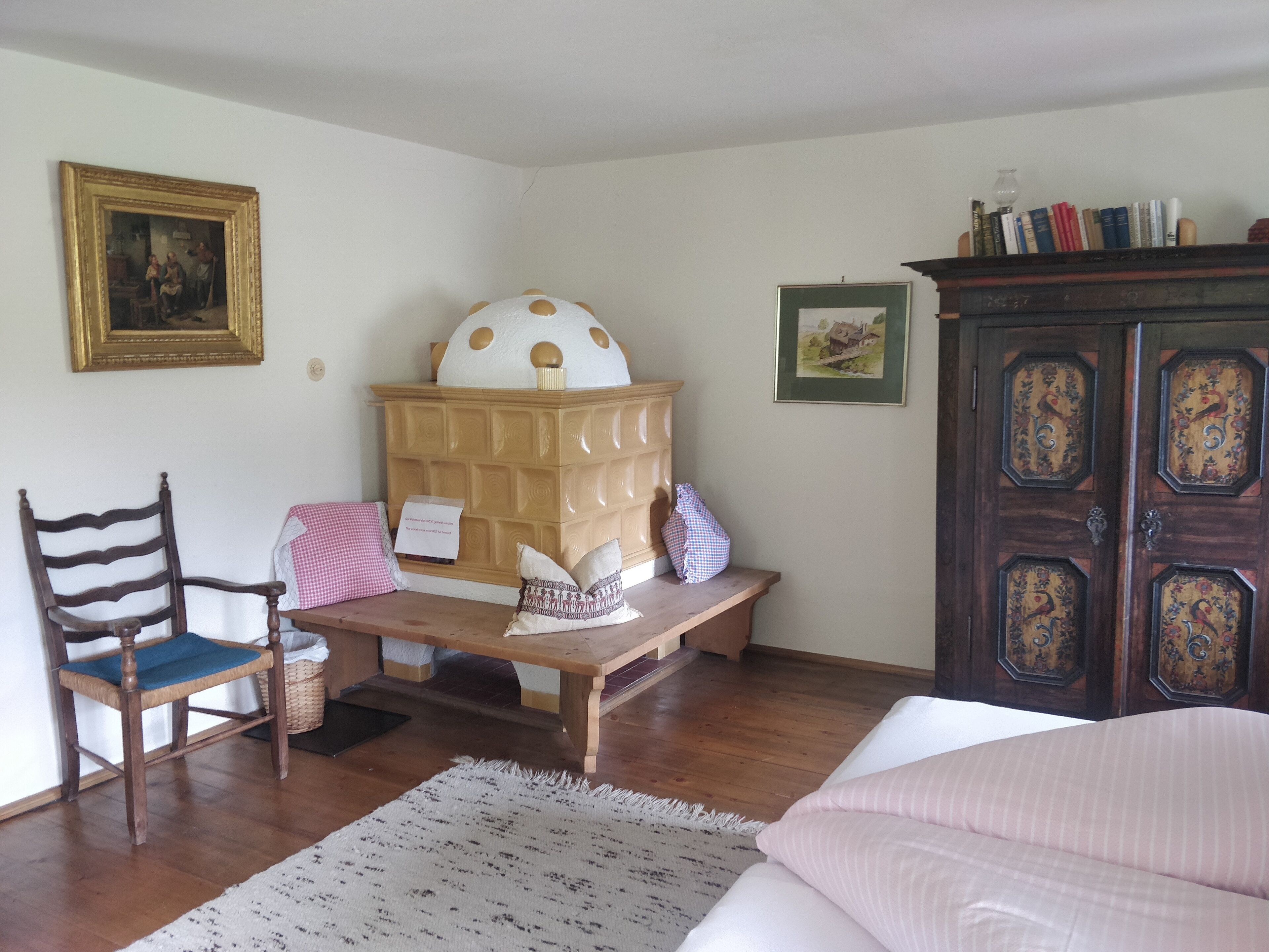 Une pièce comprenant une chaise en bois, un banc, une table, un meuble et un lit.