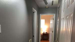 A hallway with wooden flooring, a patterned rug, and white doors on both sides. - West County Gem - Easy access to STL attractions! (Des Peres)