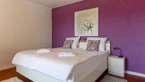 Un dormitorio con cama, mesita de noche y lámpara de pared.