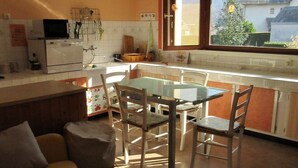 A compact kitchen with a dining area, a window with a view of the outside, and a small seating area with a couch. - Cottage 4 pers Laruns (Laruns)