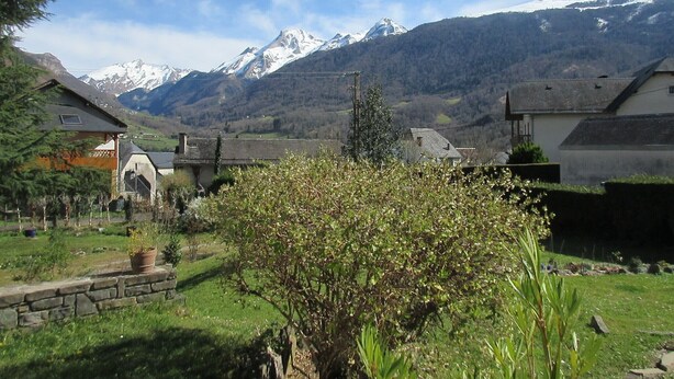 A rural village with traditional houses, a stone wall, and a mountain range in the background. - Cottage 4 pers Laruns (Laruns)
