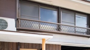 Een gebouw met een houten gevel, een schuifdeur en een bord in Japanse tekst.
