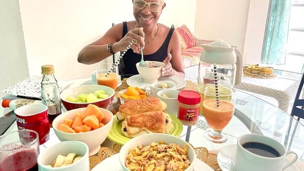 A dining table with various breakfast items including fruits, pastries, and beverages. - Cozy Apartments close to beach, bars and restaurants (Rodney Bay)