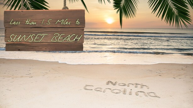 A wooden sign with "Less than 1.5 Miles to Sunset Beach" and "North Carolina" written on it. - Golf Villa | Sunset Beach | Live the Golf Life! (CV2B) (Sunset Beach)