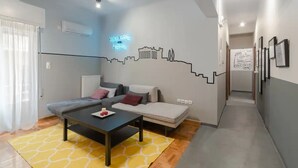 A modern living room with a sofa, a coffee table, and a wall mural.