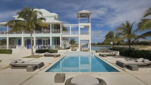 A resort with a large pool, lounge chairs, and a two-story building with balconies. - Directly on the Beach. Peaceful and Relaxing. (Nassau)