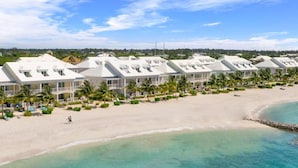 A beachfront hotel with multiple-story buildings, a sandy beach, and clear turquoise waters. - Directly on the Beach. Peaceful and Relaxing. (Nassau)