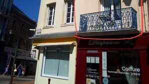 A building with a storefront labeled "Dixason" and a salon named "Laurie Poéchain" offering hair services for men, women, and children.