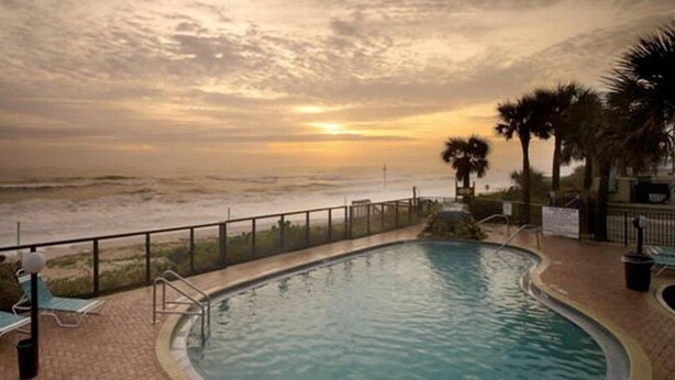 A swimming pool with a view of the beach and sunset. - Gorgeous Oceanview Condo (Ormond Beach)