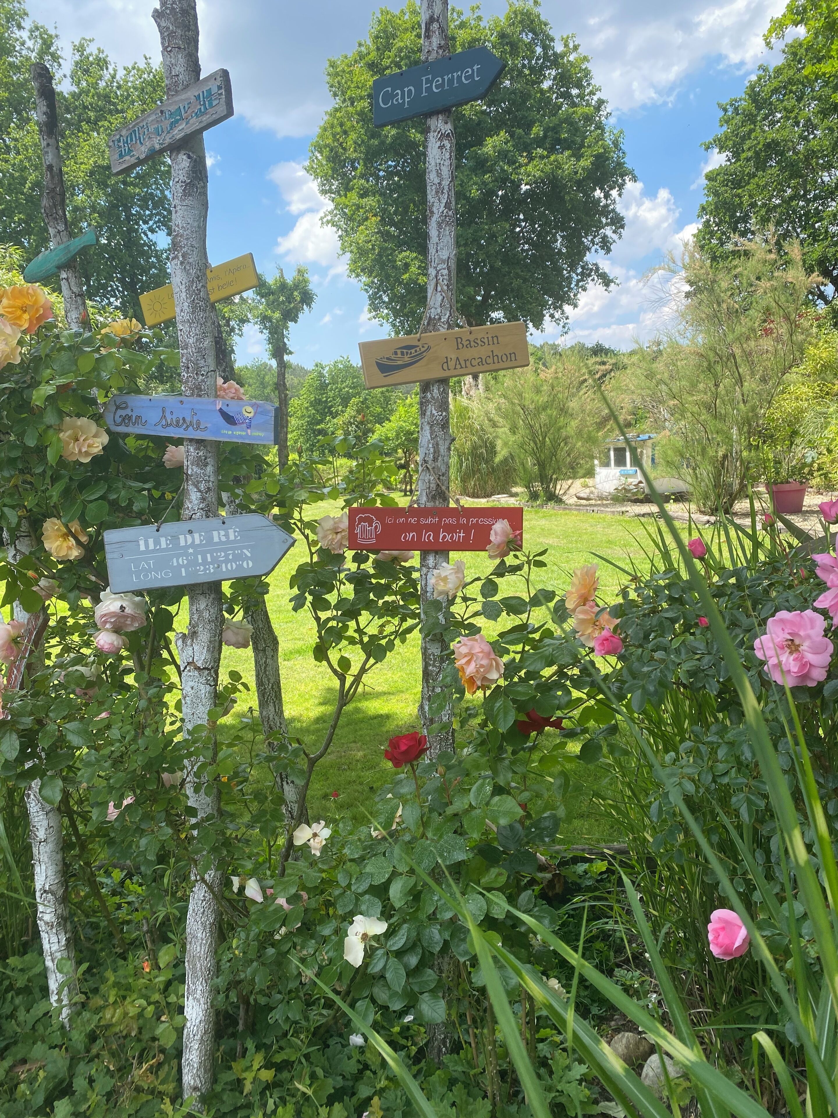 Ein Garten mit Hinweisschildern und blühenden Blumen.