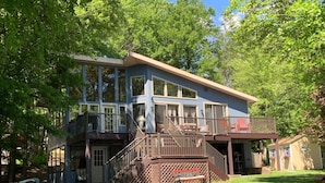 A two-story house with a balcony, a staircase, and a small porch area. - SPECTACULAR LAKEFRONT HIDEOUT RESORT-A/C- SWIM+ GOLF-KAYAK-ROWBOAT-BEACH (Hamlin)