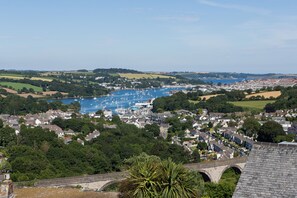 A coastal town with a marina, a bridge, and surrounding greenery.