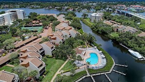 A resort with a swimming pool, dock, and river view. - Beautiful Siesta Key Condo (Siesta Key)