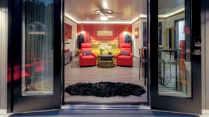 A modern interior with a red and yellow color scheme, a central round table, and two red armchairs. - Charlotte Cityscape Studio, Huge Deck, Stunning View (Charlotte)