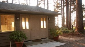 Ein Haus mit Veranda, zwei Blumentöpfen und einem Schotterweg.