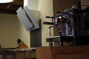 A coffee machine on a wooden counter with a chalkboard in the background.