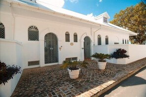 A white building with arched windows and a paved courtyard.