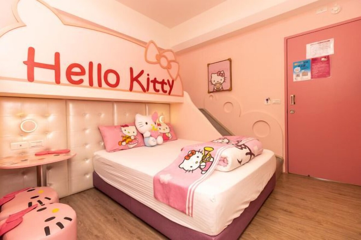 A pink-themed room with a bed, a round table, and a door.
