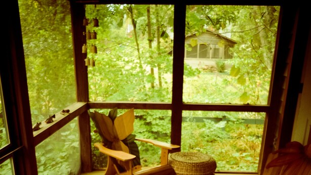 A wooden deck with two Adirondack chairs and a woven ottoman. - Lakeside Grove Cottage -  Perfect Lakeside Village/Beach Location (Lakeside)