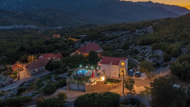 A residential area with houses, a swimming pool, and a mountain backdrop. - Holiday house Marijana (Zagvozd)