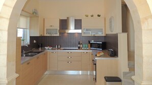 A kitchen with a central island, a microwave, a toaster, and a sink.