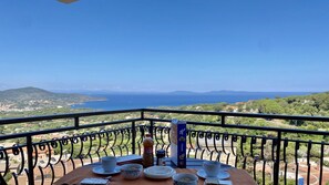 Ein Balkon mit Frühstückstisch und Blick auf die Küste.