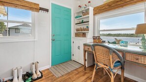 A kitchen with a teal door, wooden flooring, and a view of the water. - Home on Caney Creek with Pier & RV spot (Sargent)