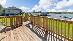 A wooden deck with a view of a lake, a house, and a dock. - Home on Caney Creek with Pier & RV spot (Sargent)