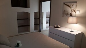 A bedroom with a bed, a bedside table with a lamp, a mirror, and a wall-mounted shelf. - MONOPOLI: "MEST PEPP "VILLA with POOL FOR EXCLUSIVE GUESTS' USE- MOSQUITOES FREE (MONOPOLI(BA))