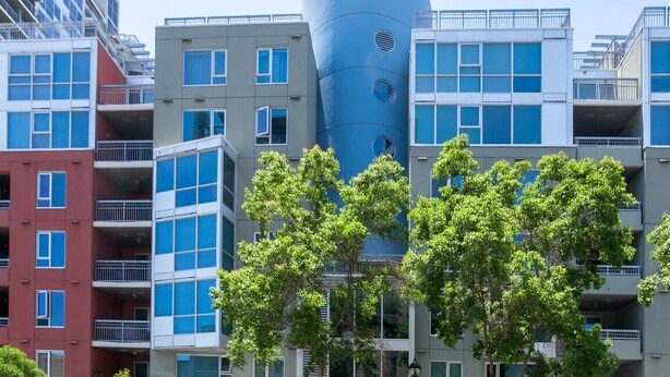 Un bâtiment moderne doté de nombreux balcons et d’une structure cylindrique originale.