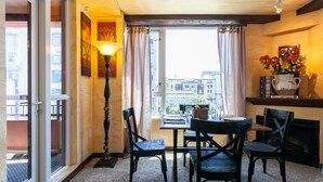 Une pièce chaleureuse avec une table à manger, des chaises, une lampe et une cheminée.