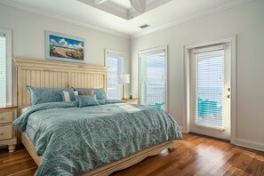 Quarto com cama, mesa de cabeceira, luminária e um quadro na parede.