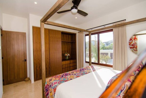 A bedroom with a bed, a ceiling fan, wooden wardrobe, and a window with curtains. - Palmilla Dunes 521 Casa Cobra 3BR w/Lux Golf Cart (Palmilla)
