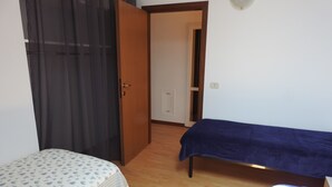 A room with a bed, a bedside table, a door, and a curtain. - Large duplex apartment sleeps 5, private parking space, in the center  (Ravenna)