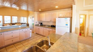 A kitchen with wooden cabinets, a stainless steel sink, and a countertop. - 6 bedrooms, elevator,  3 minute walk to the beach. (Kill Devil Hills)