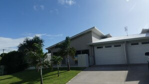 A residential house with a garage, a well-maintained lawn, and a clear sky. - Seadaze 1 - Rainbow Beach. Gorgeous unit close to the beach. Aircon. Pool. Wifi (RAINBOW BEACH)